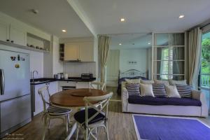 a kitchen and a living room with a couch and a table at Summer Hua Hin in Hua Hin