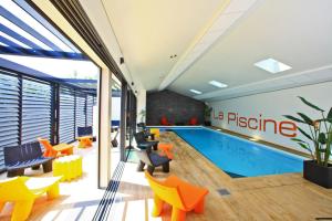 an office with a swimming pool and orange chairs at Logis Hôtel La Chaize in Noirmoutier-en-l'lle