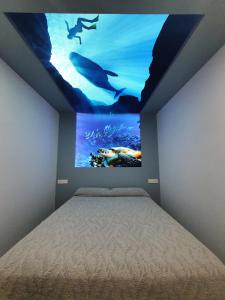 una camera da letto con un letto e un acquario sul muro di Casa Cetáceo a Playa Quemada