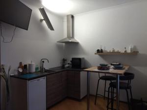 Chezmoi في كورمايور: مطبخ مع حوض ومكتب مع طاولة