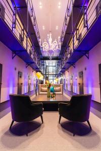 een lobby met 2 stoelen en een bank in een gebouw bij Het Arresthuis in Roermond