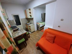 a living room with an orange couch and a kitchen at Smeštaj Milenković in Soko Banja