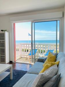 スラック・シュル・メールにあるGrand appartement 1ch vue Océanのリビングルーム(ベッド付)が備わり、海の景色を望めます。