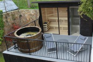 a deck with a hot tub and chairs and a house at Agroturismo Haitzalde B&B - Adults Only in Mutriku