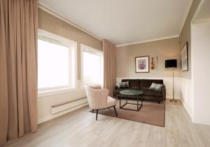 a living room with a couch and a table at Røros Hotell - Bad & Velvære in Røros