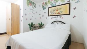 ein Schlafzimmer mit einem Bett mit Schmetterlingen an der Wand in der Unterkunft Cristian Jay Dormitory by RedDoorz in Dasmariñas