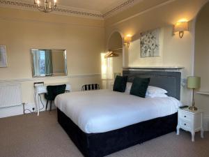 a bedroom with a large white bed and a desk at Ardross Glencairn in Inverness