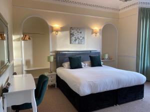a hotel room with a large bed and a desk at Ardross Glencairn in Inverness