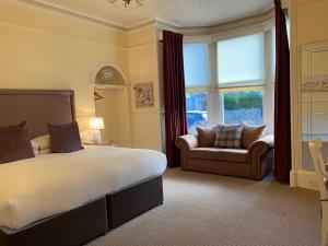 a bedroom with a bed and a chair and a window at Ardross Glencairn in Inverness