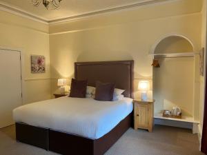 a bedroom with a bed with white sheets and two lamps at Ardross Glencairn in Inverness