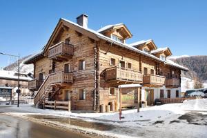 a log cabin with snow in front of it at Rasia Residence Relax Stone in Livigno