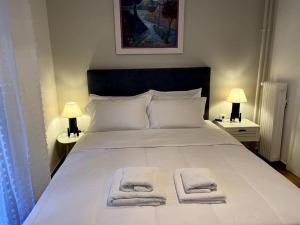 ein Schlafzimmer mit einem weißen Bett und Handtüchern darauf in der Unterkunft Cozy and comfortable apartment in Athens Center in Athen