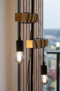 a group of three lights hanging from a wall at Nowa Grochowska Apartments in Warsaw