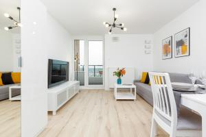 Televízia a/alebo spoločenská miestnosť v ubytovaní Elegancki Apartment z Parkingiem by Noclegi Renters