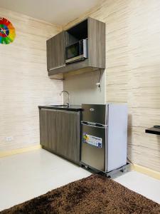 a kitchen with a refrigerator and a microwave at Solemare Parksuites Condo in Manila