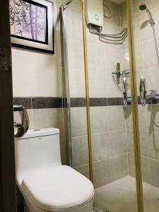 a bathroom with a toilet and a shower at Solemare Parksuites Condo in Manila