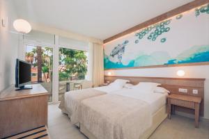a bedroom with a bed and a tv and a window at Iberostar Waves Las Dalias All Inclusive in Adeje +74 photos
