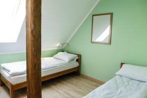 um pequeno quarto com 2 camas e um espelho em Sweet Home Hostel em Chernivtsi
