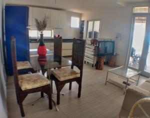 uma sala de jantar com mesa e cadeiras e uma cozinha em Apartamento Duplex beira Mar em Nísia Floresta