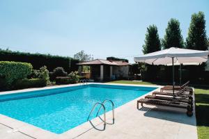 a swimming pool with two chairs and an umbrella at Feel Discovery Casa Da Capela Douro Valley Armamar in Armamar