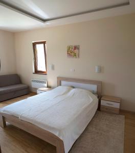 a bedroom with a large bed and a couch at Apartments Admiral in Herceg-Novi
