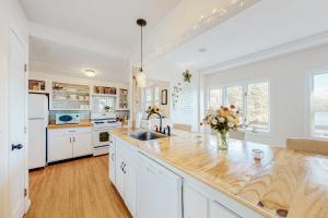 a kitchen with white cabinets and a wooden counter top at Heavenly Lakefront in Plymouth