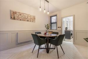 Guest Homes - Barton Road Retreat في هيريفورد: غرفة طعام مع طاولة وكراسي