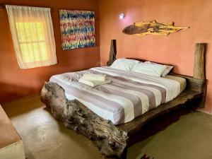 a bedroom with a bed made out of a log at Nemasu Eco-lodge in Gunjur
