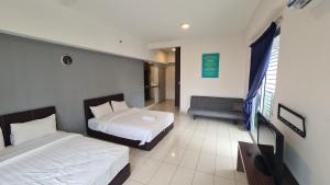 a hotel room with two beds and a couch at KK Aeropod Corner unit A near Airport and City Free Parking in Kota Kinabalu
