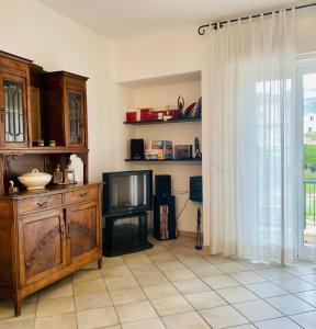 a living room with a tv on a tiled floor at Dimora Concept - Casa Leon - Bike room in Finale Ligure