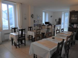 - une salle à manger avec des tables, des chaises et des fenêtres dans l'établissement Le Relais des Cavaliers, à Villeneuve-dʼEntraunes