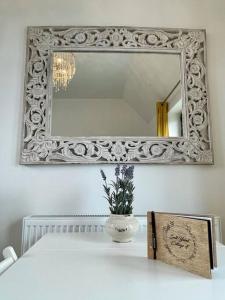 un miroir sur un mur avec un vase sur une table dans l'établissement Whitstable - Salt Yard Cottage 4, à Whitstable