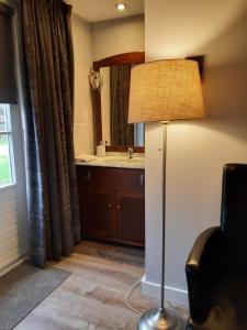 a room with a bathroom with a sink and a lamp at Chambre d'Hotes Beesel in Beesel