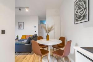 een woonkamer met een tafel en stoelen en een bank bij Cosy, furnished & renovated flat with outside lounge in Gent