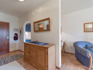 a living room with a blue couch and a mirror at Ferienwohnanlage Bergschlößl Wohnung Nr 9 in Oberaudorf