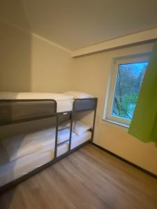 Zimmer mit 2 Etagenbetten und einem Fenster in der Unterkunft Rheinsteig Quartier by bestprice Hotels in Bendorf