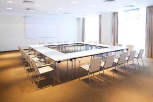 una sala de conferencias con una mesa grande y sillas en The Gerald's Hotel en Rădăuţi