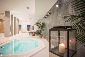 Focus Hotel Premium Lublin Conference & SPA في لوبلين: حمام سباحة مع شمعة في غرفة مع شمعة مضاءة