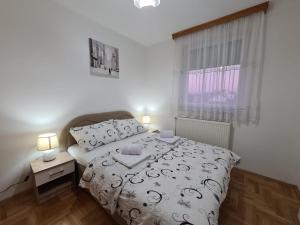 1 dormitorio con cama y ventana en Apartman City, en Bijeljina