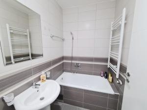 a bathroom with a sink and a bath tub at Apartman City in Bijeljina