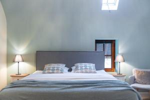 ハッセルトにあるWinning De Zwaenのベッドルーム1室(大型ベッド1台、ランプ2つ、椅子付)