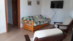 a living room with a bed and a chair at AIRES DE TANDIL in Tandil