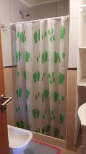 a bathroom with a shower curtain with a green footprint at AIRES DE TANDIL in Tandil
