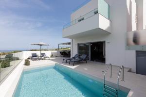 a villa with a swimming pool and a house at Blue Aura Villa, elegance & calm living, By ThinkVilla in Magnisía