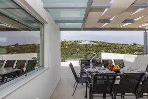a dining room with a table and chairs and a large window at Blue Aura Villa, elegance & calm living, By ThinkVilla in Magnisía