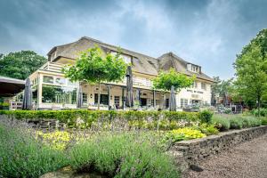 een groot huis met een tuin ervoor bij Landgoed De Uitkijk Hellendoorn in Hellendoorn