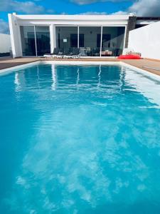 duży niebieski basen przed domem w obiekcie Villa Nepal w mieście Playa Blanca
