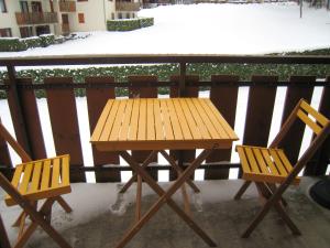 uma mesa de madeira e 2 cadeiras numa varanda em Appartement d'une chambre a Bernex a 50 m des pistes avec balcon et wifi em Bernex