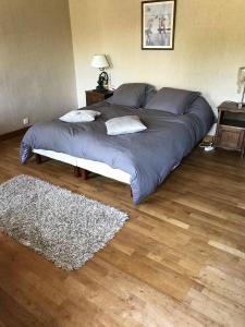duże łóżko w pokoju z dywanem w obiekcie Maison de 7 chambres avec vue sur le lac jardin clos et wifi a Le Dezert w mieście Montmartin-en-Graignes
