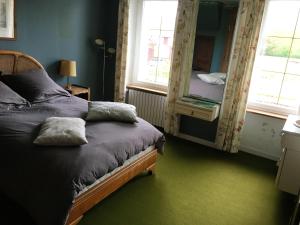 sypialnia z łóżkiem i lustrem w obiekcie Maison de 7 chambres avec vue sur le lac jardin clos et wifi a Le Dezert w mieście Montmartin-en-Graignes